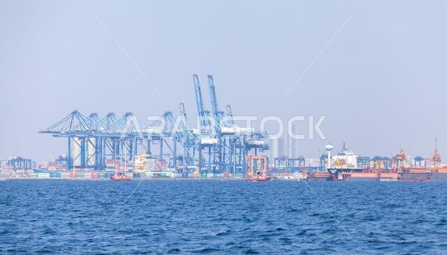 Jeddah, Saudi Arabia - December 22, 2019: Gantry cranes and containers at Jeddah port on a sunny summer day