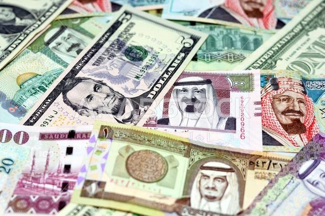أوراق نقدية من الريال السعودي مع أوراق نقدية من الدولار الأمريكي، تركيز انتقائي على الريال السعودي، ودولار الولايات المتحدة الأمريكية