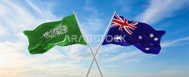 علمان متقاطعان، علم السعودية وعلم أستراليا، يرفرفان في مهب الريح تحت سماء ملبدة بالغيوم. يرمزان إلى العلاقة والحوار والسفر بين البلدين. رسم توضيحي ثلاثي الأبعاد
