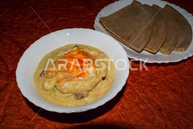 Turkish or Arabic food cuisine Hummus or Humus served in bowl. Hummus dip garnished with red chilly paprika and olive oil served in white bowl with wh Turkish or Arabic food cuisine Hummus or Humus served in bowl. Hummus dip garnished with red chilly paprika and olive oil served in white bowl with wh