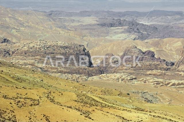 aerial view of the rocks coming out of the sandy desert terrain in the Middle East