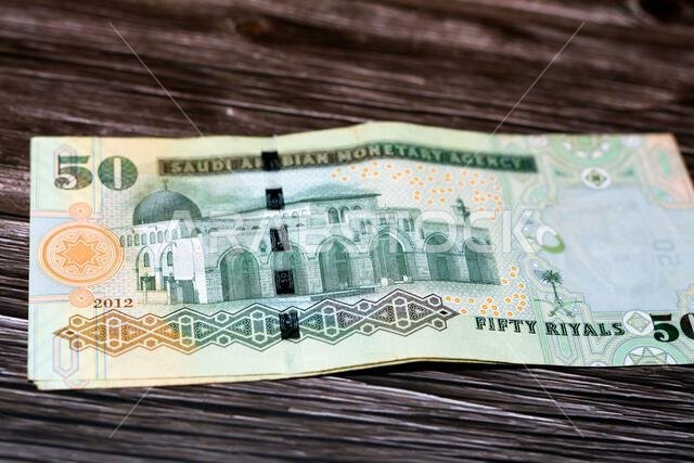 Stack of the reverse side of Saudi Arabia 50 SAR fifty Saudi riyals cash money banknote with the photo of Al Aqsa Mosque in Jerusalem isolated on a wo