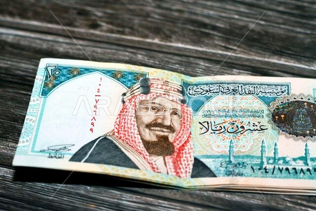Stack of Saudi Arabia 20 SAR twenty Saudi riyals cash money banknote with the photo of king AbdulAziz Al Saud and Quba mosque in Madinah isolated on a