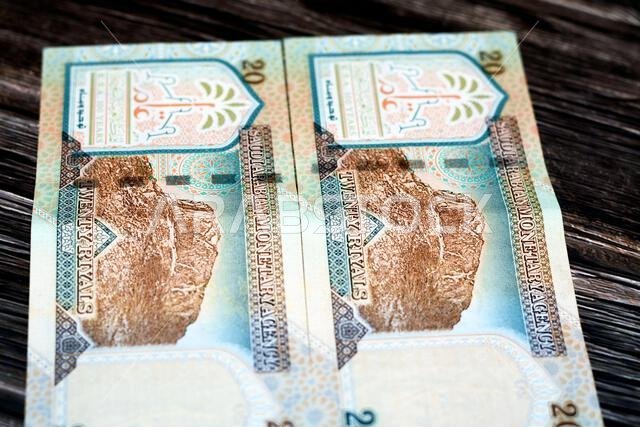 يُظهر الوجه الخلفي للورقة النقدية السعودية فئة 20 ريالاً جبل النور، وهو جبل يقع بالقرب من مكة المكرمة في منطقة الحجاز.