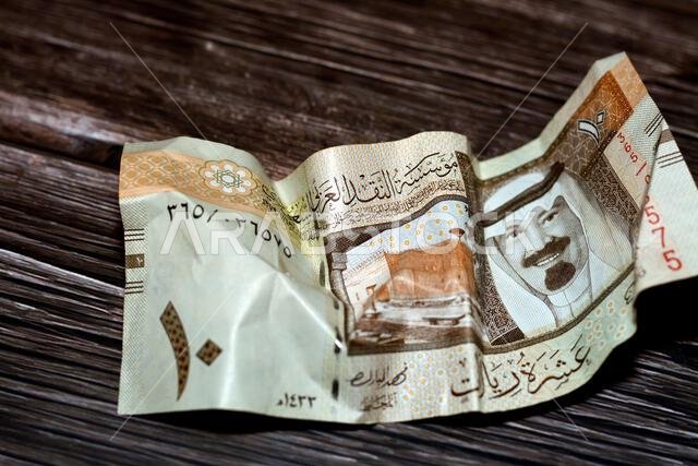 ورقة نقدية سعودية مجعدة من فئة 10 ريالات، معزولة على خلفية خشبية، ورقة نقدية سعودية مجعدة من فئة 10 ريالات، تضخم العملة السعودية ورقة نقدية سعودية مجعدة من فئة 10 ريالات، معزولة على خلفية خشبية، ورقة نقدية سعودية مجعدة من فئة 10 ريالات، تضخم العملة السعودية
