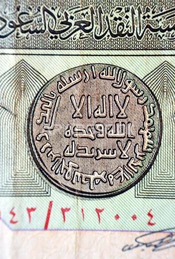 A closeup of Arabic text from the obverse side of an old 1 one Saudi Arabia riyal banknote, Translation (There is no god but Allah alone, who has no p A closeup of Arabic text from the obverse side of an old 1 one Saudi Arabia riyal banknote, Translation (There is no god but Allah alone, who has no p