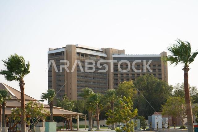 مبنى شاهق ذو سماء زرقاء، تحيط به بعض أشجار النخيل، والطقس عاصف. المملكة العربية السعودية، الخبر، ١٠ يونيو ٢٠٢٢.