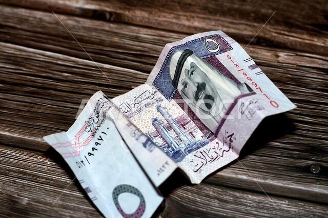 Crumpled Saudi Arabia money of 5 SAR five riyals isolated on wooden background, wrinkled 5 Saudi Riyals cash bill banknote, Saudi money inflation and