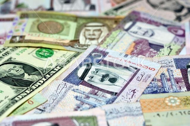أوراق نقدية من الريال السعودي مع أوراق نقدية من الدولار الأمريكي، تركيز انتقائي على الريال السعودي، ودولار الولايات المتحدة الأمريكية أوراق نقدية من الريال السعودي مع أوراق نقدية من الدولار الأمريكي، تركيز انتقائي على الريال السعودي، ودولار الولايات المتحدة الأمريكية