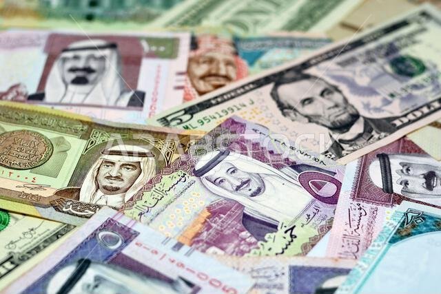 أوراق نقدية من الريال السعودي مع أوراق نقدية من الدولار الأمريكي، تركيز انتقائي على الريال السعودي، ودولار الولايات المتحدة الأمريكية أوراق نقدية من الريال السعودي مع أوراق نقدية من الدولار الأمريكي، تركيز انتقائي على الريال السعودي، ودولار الولايات المتحدة الأمريكية