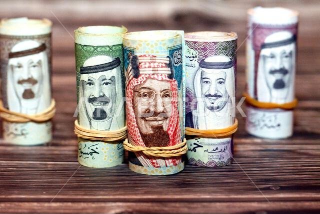 أوراق نقدية من فئة الريال السعودي ملفوفة بأربطة مطاطية، من فئات 100 و50 و20 ريالاً. أوراق نقدية من فئة الريال السعودي ملفوفة بأربطة مطاطية، من فئات 100 و50 و20 ريالاً.
