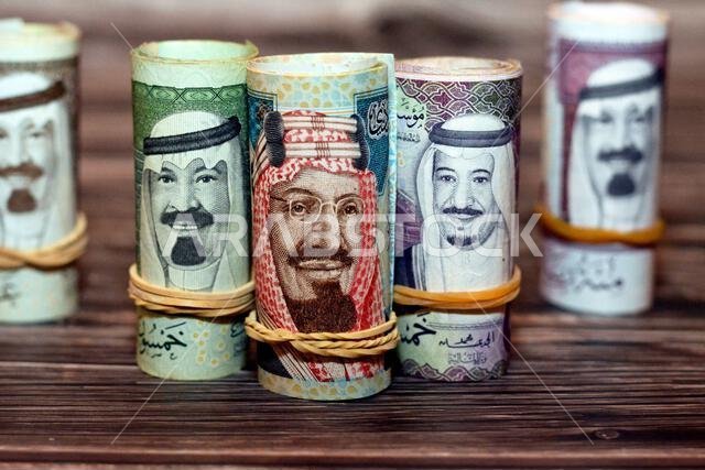 أوراق نقدية من الريال السعودي ملفوفة بأربطة مطاطية من فئات 100 و50 و20 ريالاً.