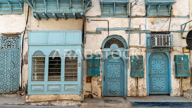 The facade of historical houses with intricate blue doors in the town of Al Balad, Jeddah, Saudi Arabia