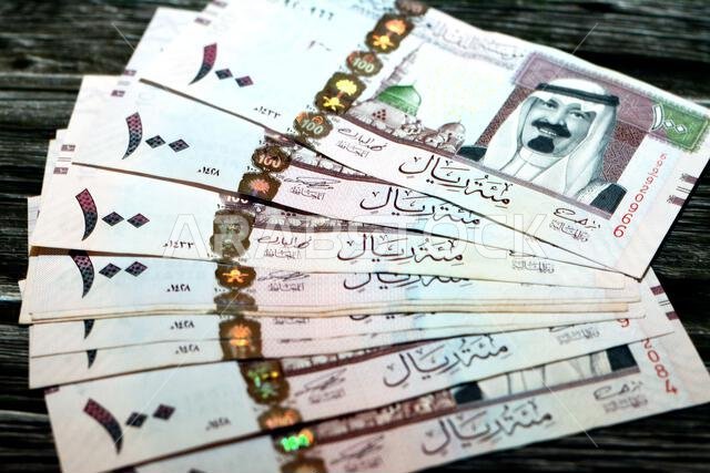 رزمة من الأوراق النقدية السعودية فئة 100 ريال سعودي، تحمل صورة الملك عبد الله بن عبد العزيز آل سعود والمسجد النبوي في المدينة المنورة.