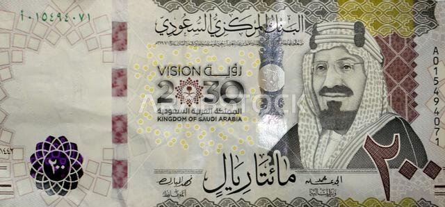Large fragment of the obverse side of 200 two hundred Saudi riyals banknote features King Abdul Aziz Al Saud the founder of the kingdom and a 3D logo