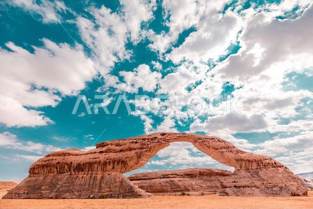 صخرة قوس قزح الجميلة في يوم مشمس تحت سماء جميلة مليئة بالغيوم في العلا، المملكة العربية السعودية صخرة قوس قزح الجميلة في يوم مشمس تحت سماء جميلة مليئة بالغيوم في العلا، المملكة العربية السعودية