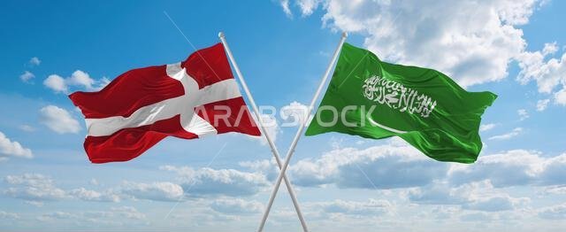 two crossed flags Saudi Arabia and Denmark waving in wind at cloudy sky. Concept of relationship, dialog, travelling between two countries. 3d illustr