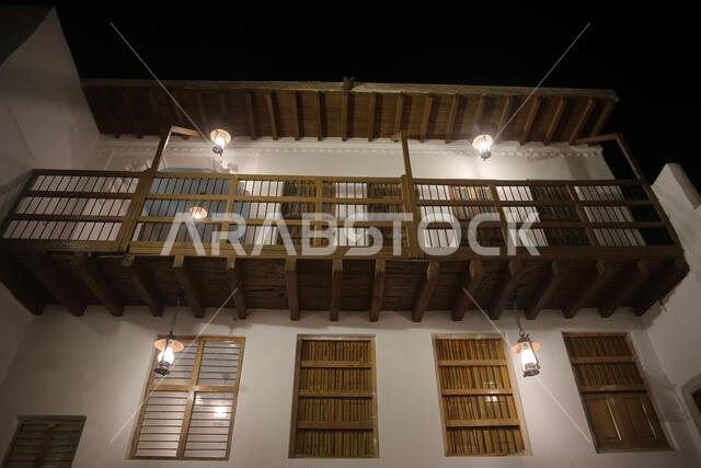 A low-angle shot of an old Arab house at night ,lit by old lamps