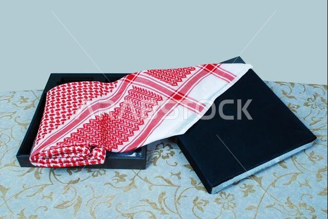 Arab Muslim men,s cultural head scarf named Shemagh ghutrah isolated red and white fabric clothing accessory middle eastern traditional dressing