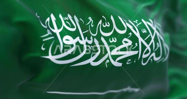 صورة مقرّبة لعلم المملكة العربية السعودية وهو يرفرف في مهب الريح. المملكة العربية السعودية (KSA) دولة تقع في شبه الجزيرة العربية في غرب آسيا