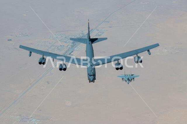 A Royal Saudi Air Force F-15 flies with a U.S. Air Force B-52H Stratofortress above the Kingdom of Saudi Arabia, March 29, 2022. The presence of the B-52H showcases U.S. Central Command's ability to deliver combat airpower at a moment's notice, as well as its commitment to partners and regional security. (U.S. Air Force photo by Staff Sgt. Joseph Pick)