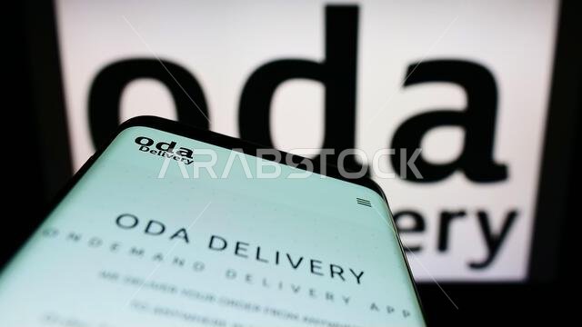 Smartphone with webpage of Saudi Arabian logistics company Oda Delivery on screen in front of business logo. Focus on top-left of phone display.