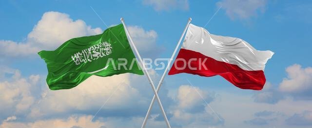 علمان متقاطعان، علم السعودية وعلم بولندا، يرفرفان في مهب الريح تحت سماء ملبدة بالغيوم. يرمز هذا العمل الفني إلى مفهوم العلاقة والحوار والسفر بين البلدين. رسم ثلاثي الأبعاد.