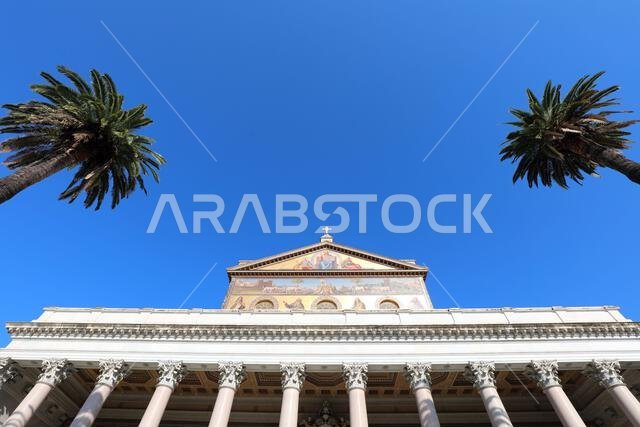 Rome, RM, Italy - August 16, 2020: Facade of Basilica Saint Paul Outside of Walls called SAN PAOLO FUORI LE MURA in Italian Language and palms