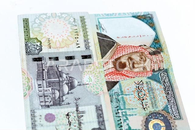 Obverse sides of Saudi Arabia 20 twenty riyals banknote with 20 LE twenty Egyptian pounds bill isolated on a white background, Selective focus of Egyp Obverse sides of Saudi Arabia 20 twenty riyals banknote with 20 LE twenty Egyptian pounds bill isolated on a white background, Selective focus of Egyp