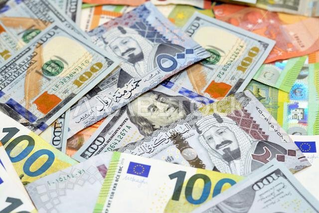 نقود من الريال السعودي مع أوراق نقدية من الدولار الأمريكي واليورو الأوروبي، رزمة من 200 و500 ريال سعودي، و100 دولار، و10