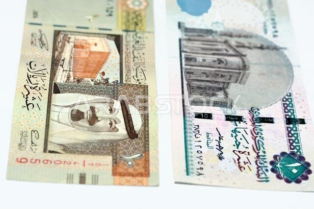 وجهان لعملة ورقية قديمة من فئة 10 ريالات سعودية مع ورقة نقدية من فئة 10 جنيهات مصرية معزولة على خلفية بيضاء، مع تركيز انتقائي على مصر.