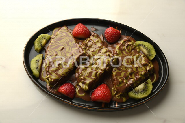 A close-up of the delicious waffle plate with pieces of fruit, oriental sweets, Ramadan sweets, sweets and sugars, delicious pieces of sweets, sweets, delicious cold sweets, waffles pieces