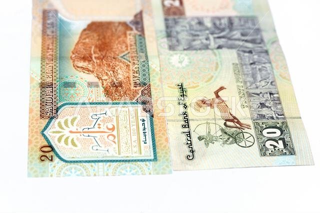 الوجه الخلفي لورقة نقدية سعودية من فئة 20 ريالاً مع ورقة نقدية مصرية من فئة 20 جنيهاً مصرياً، معزولة على خلفية بيضاء، مع تركيز انتقائي على مصر الوجه الخلفي لورقة نقدية سعودية من فئة 20 ريالاً مع ورقة نقدية مصرية من فئة 20 جنيهاً مصرياً، معزولة على خلفية بيضاء، مع تركيز انتقائي على مصر