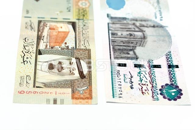 Obverse sides of an old Saudi Arabia 10 ten riyals banknote with 10 LE ten Egyptian pounds bill isolated on a white background, Selective focus of Egy