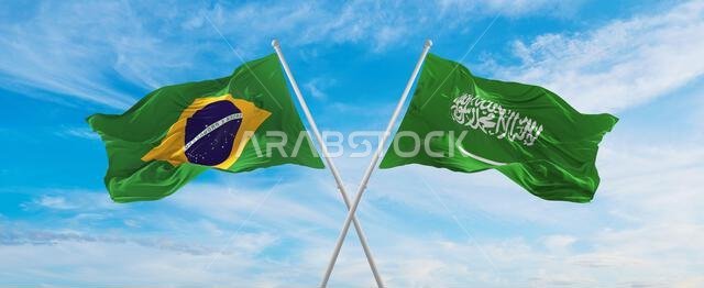 تتقاطع أعلام البرازيل والسعودية الوطنية وترفرف في مهب الريح تحت سماء ملبدة بالغيوم، رمزاً للعلاقات والحوار والسفر بين البلدين.