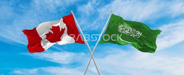 crossed national flags of Canada and Saudi Arabia flag waving in the wind at cloudy sky. Symbolizing relationship, dialog, travelling between two coun crossed national flags of Canada and Saudi Arabia flag waving in the wind at cloudy sky. Symbolizing relationship, dialog, travelling between two coun