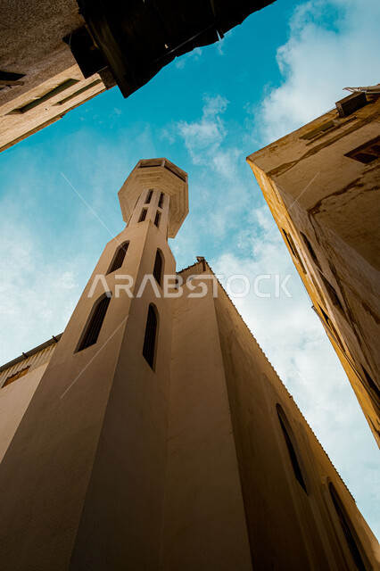 صورة بزاوية من الاسفل لمئذنة مسجد في البلد التاريخي بجدة في المملكة العربية السعودية، المدينة التاريخية في جدة، التصميم المعماري العربي القديم، العبادة والتقرب الى الله، المعالم التاريخية في جدة