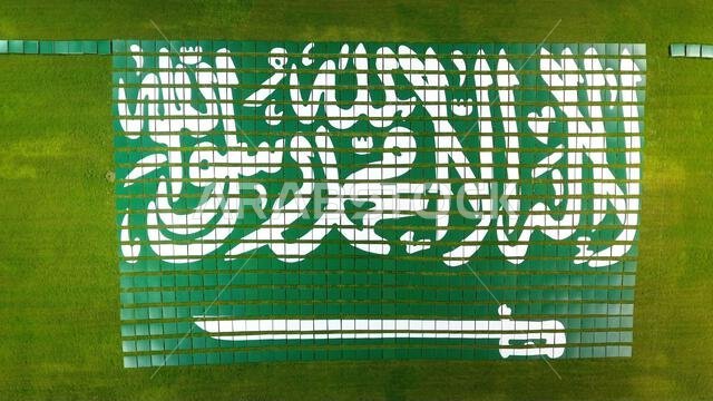 لقطة جوية التقطتها طائرة بدون طيار لعلم المملكة العربية السعودية الذي تشكل على شكل قطع فنية على أرض عشبية