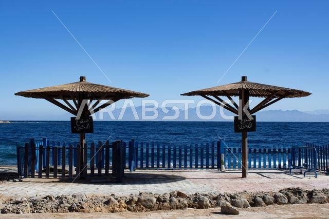 Two wooden umbrellas on the seashore alone in Egypt