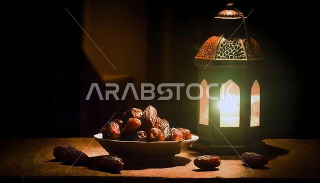 Ramadan concept. Dates close-up in the foreground. Ramadan Lantern on a wooden table. Ramadan concept. Dates close-up in the foreground. Ramadan Lantern on a wooden table.