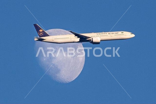 طائرة تابعة للخطوط الجوية السعودية من طراز إيرباص A350-900 تعبر القمر المتزايد فوق شمال لندن، المملكة المتحدة، أثناء اقترابها من مطار هيثرو.