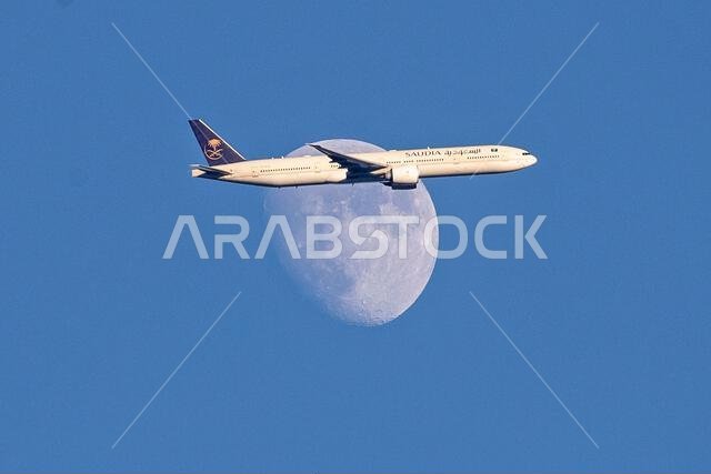 طائرة تابعة للخطوط الجوية السعودية من طراز إيرباص A350-900 تعبر القمر المتزايد فوق شمال لندن، المملكة المتحدة، أثناء اقترابها من مطار هيثرو.