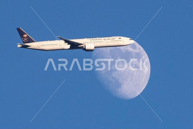 طائرة تابعة للخطوط الجوية السعودية من طراز إيرباص A350-900 تعبر القمر المتزايد فوق شمال لندن، المملكة المتحدة، أثناء اقترابها من مطار هيثرو.