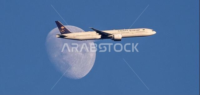 Saudi Arabian Airlines A350-900 plane passes the waxing moon above North London, United Kingdom as it approaches Heathrow Airport