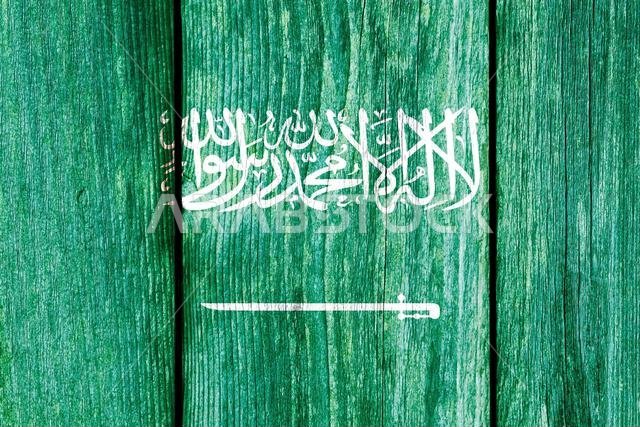 نمط خشن لعلم المملكة العربية السعودية معزول على لوح سياج خشبي متآكل.
