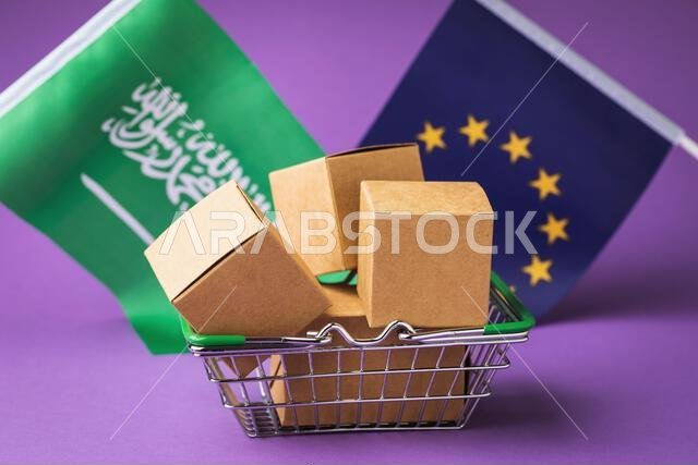 صناديق كرتونية في سلة طعام وأعلام على خلفية ملونة، مفهوم التجارة بين الاتحاد الأوروبي والمملكة العربية السعودية صناديق كرتونية في سلة طعام وأعلام على خلفية ملونة، مفهوم التجارة بين الاتحاد الأوروبي والمملكة العربية السعودية