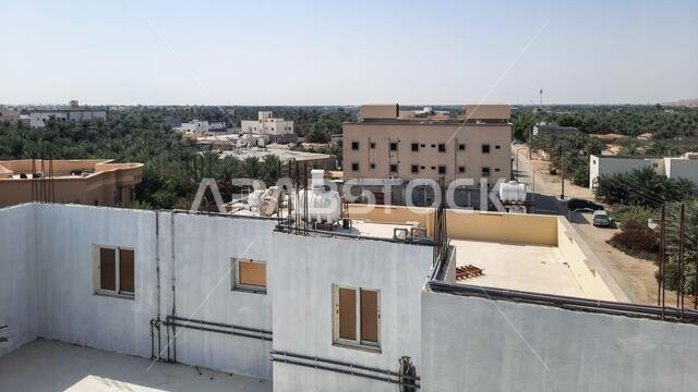 الأحساء، المملكة العربية السعودية - ٢٧ أكتوبر ٢٠٢١: أسطح المباني تحت سماء صافية في الأحساء، المملكة العربية السعودية