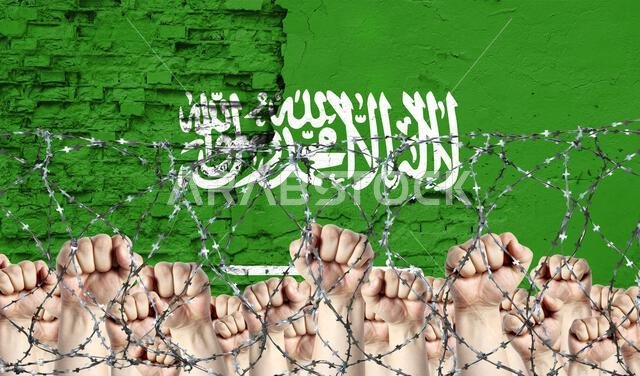 أسلاك شائكة على خلفية علم المملكة العربية السعودية الممزق وقبضات مرفوعة