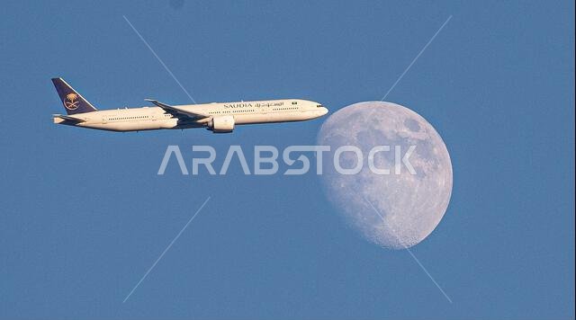طائرة تابعة للخطوط الجوية السعودية من طراز إيرباص A350-900 تعبر القمر المتزايد فوق شمال لندن، المملكة المتحدة، أثناء اقترابها من مطار هيثرو.