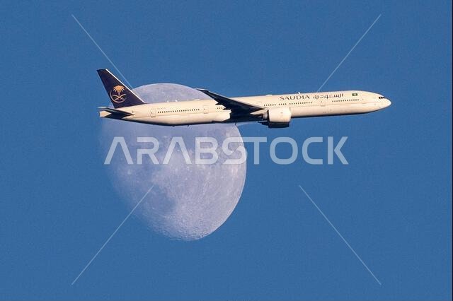 طائرة تابعة للخطوط الجوية السعودية من طراز إيرباص A350-900 تعبر القمر المتزايد فوق شمال لندن، المملكة المتحدة، أثناء اقترابها من مطار هيثرو.